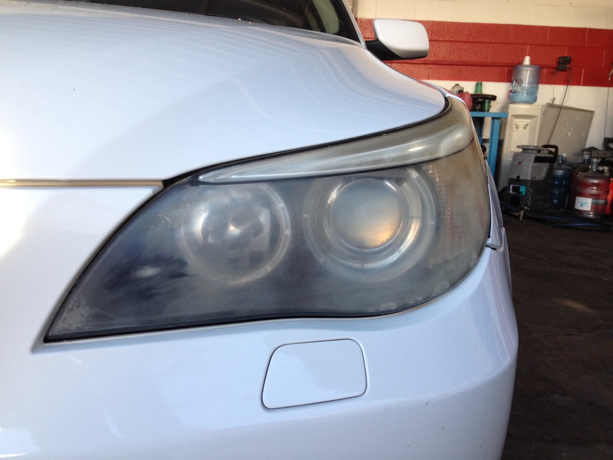 Same BMW headlight before restoration — heavily oxidized and hazed with visible cloudiness across the lens